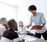 Business leader speaking confidently with colleagues, illustrating how to develop confidence and strengthen leadership effectiveness.